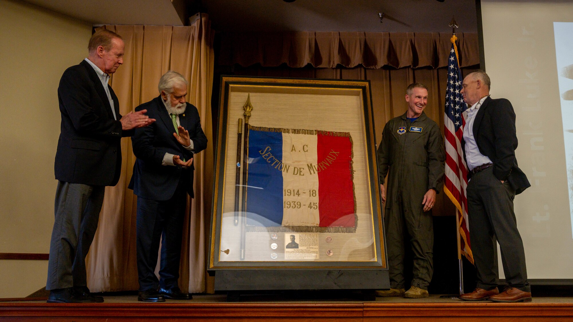 Participants in the Murvaux flag ceremony celebrate the unveiling the Murvaux flag May, 7, 2023, at Luke Air Force Base, Arizona.