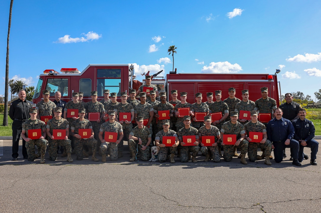 U.S. Marines stationed on Marine Corps Air Station Miramar, pose for a group photo to commemorate 29 Marines becoming certified wildland firefighters on MCAS Miramar, March 24, 2023. These Marines have trained to become wildland firefighters to form the first hand crew composed primarily of U.S. Marines. (U.S. Marine Corps photo by Lance Cpl. Jackson Rush)