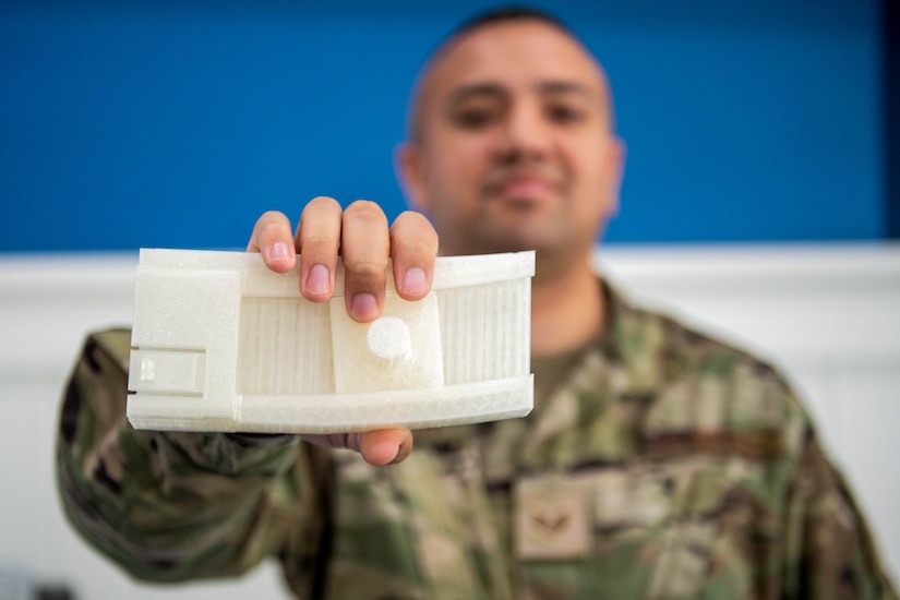 A man holds up a 3D printed object