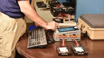 Special Agent examining computer hard drives in the lab