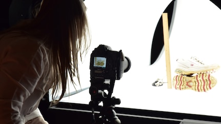 Forensic Scientist examining and taking pictures of footwear evidence in a light box, in the lab