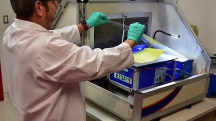 Forensic Scientist examining a piece of paper evidence in the lab