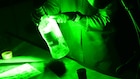 Forensic Scientist examining fingerprints on a bottle in the lab