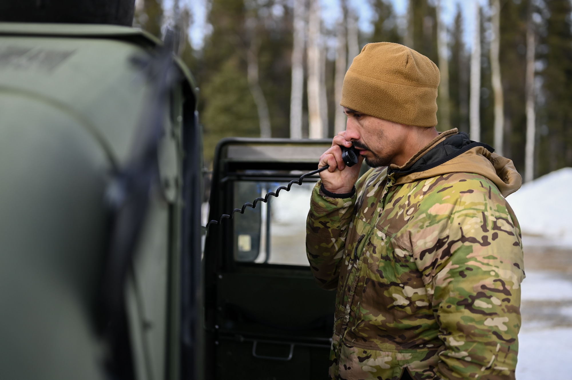 U.S. Air Force Capt. Edwardo Ramirez, 3rd Air Support Operations Squadron flight commander, receives updates from a sensory and effects team during an arctic training in Delta Junction, Alaska, March 22, 2023.