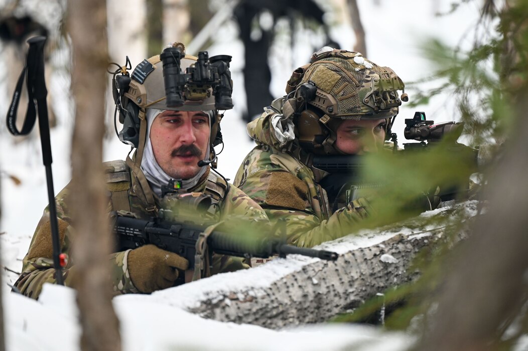 U.S. Air Force Staff Sgt. John Engerraan, 3rd Air Support Operations Squadron sensors and effects team supervisor, and Airman 1st Class Cameron St Amand, 3 ASOS precision strike operator, survey the area during an arctic training in Delta Junction, Alaska, March 22, 2023.