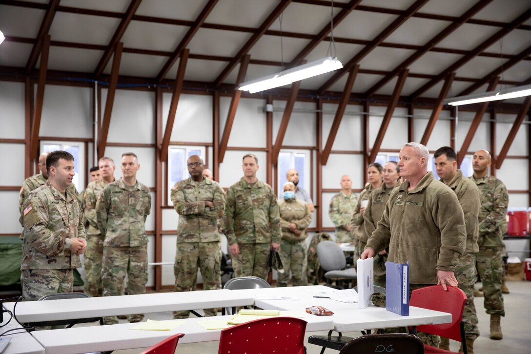 A group of Soldiers having a conversation in a warehouse.