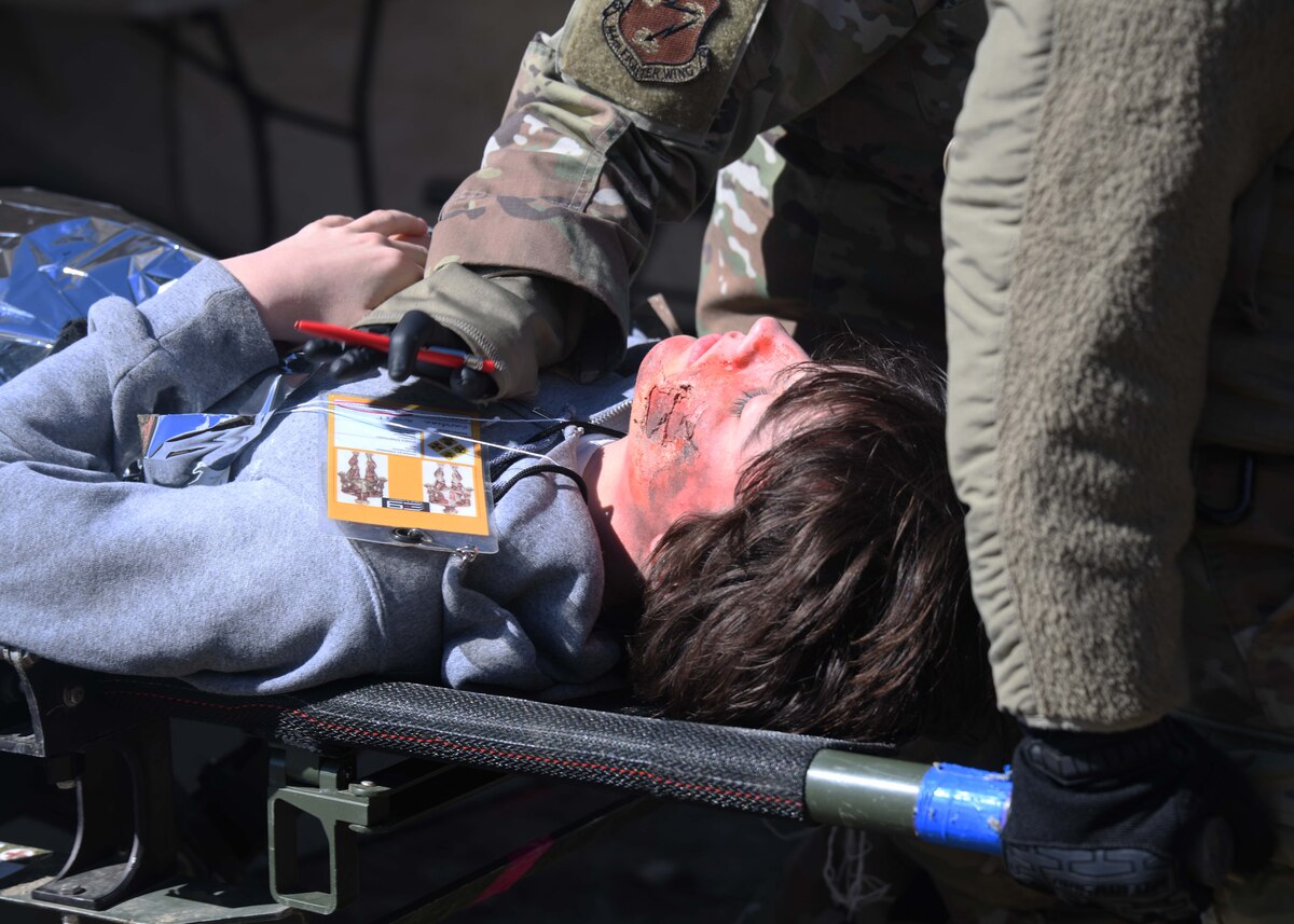 A close up of an actor being moved on a stretcher