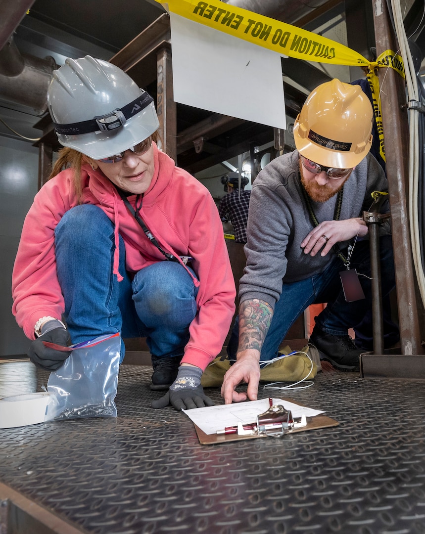 Shipfitter Michelle Coulson, Shop 11, Shipfitter, and James Broshears, instructor, Shop 17, Sheet Metal, work on a deck structure project on a mock up inside the School of Steel at Puget Sound Naval Shipyard & Intermediate Maintenance Facility in Bremerton, Washington. (U.S. Navy photo by Wendy Hallmark)