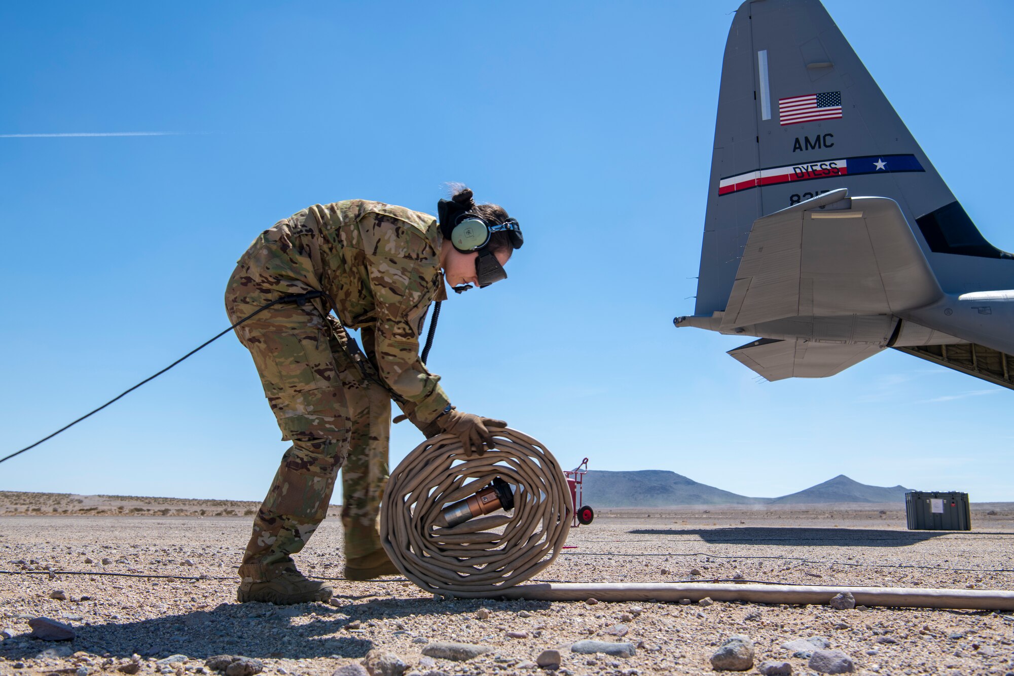 U.S. Air Force Tech. Sgt. Tristan Geray, 40th Airlift Squadron loadmaster, wraps up a fuel hose during Operation Night King in the California desert March 26, 2023.