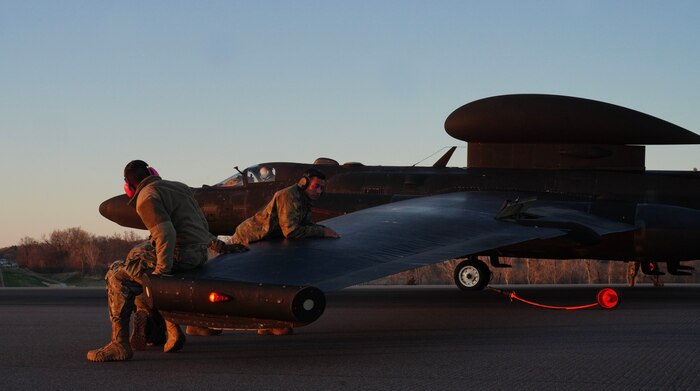 A U.S. Air Force 9th Aircraft Maintenance Squadron Airman and a 9th MXS Airman weigh on the wing of a U-2 Dragon Lady to place a pogo during Dragon Flag EAST, April 5, 2023, at Offutt Air Force Base, Nebraska.