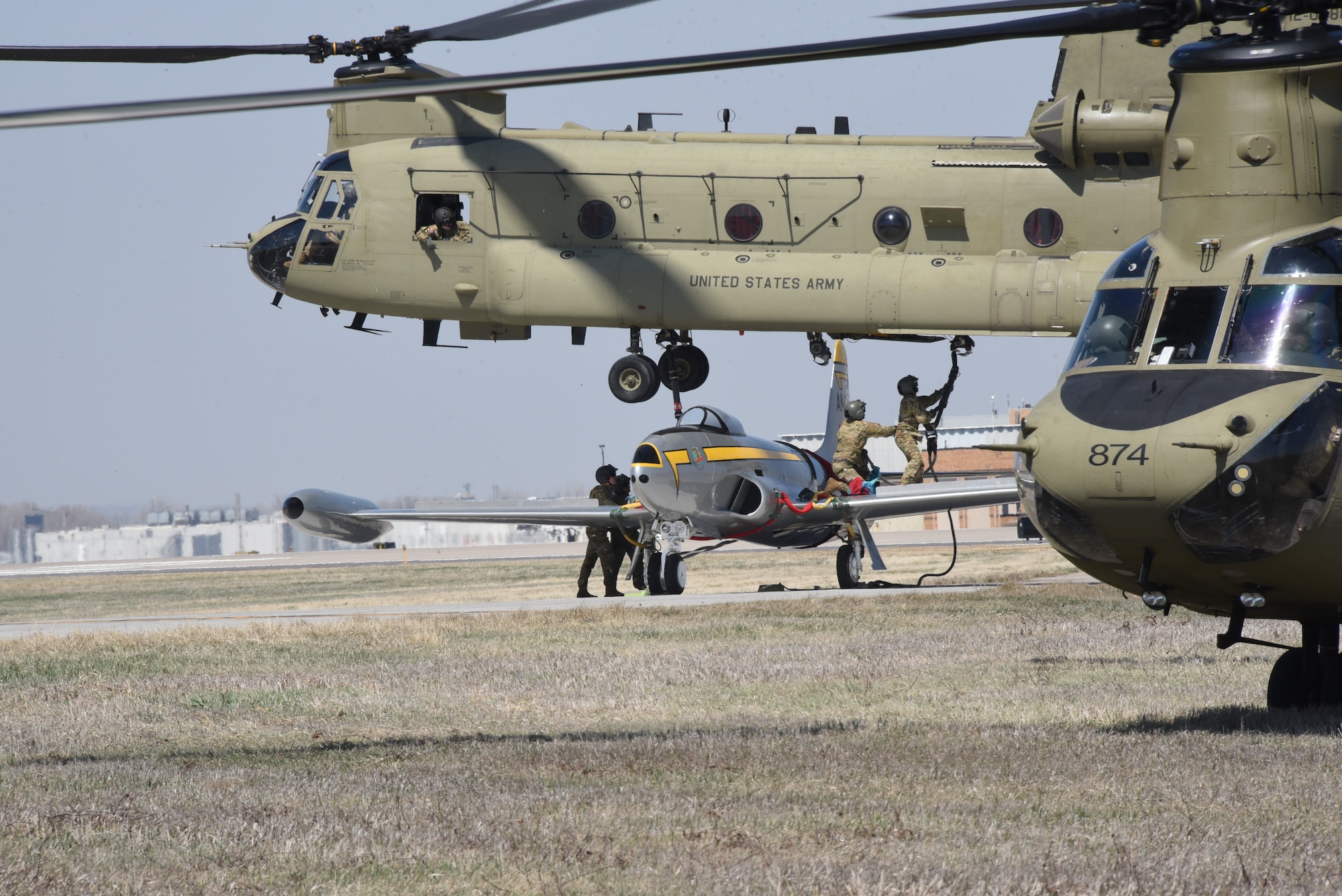 Iowa Army National Guard CH-47 Chinook helicopter picks up a F-80 fighter jet at the Air National Guard paint facility