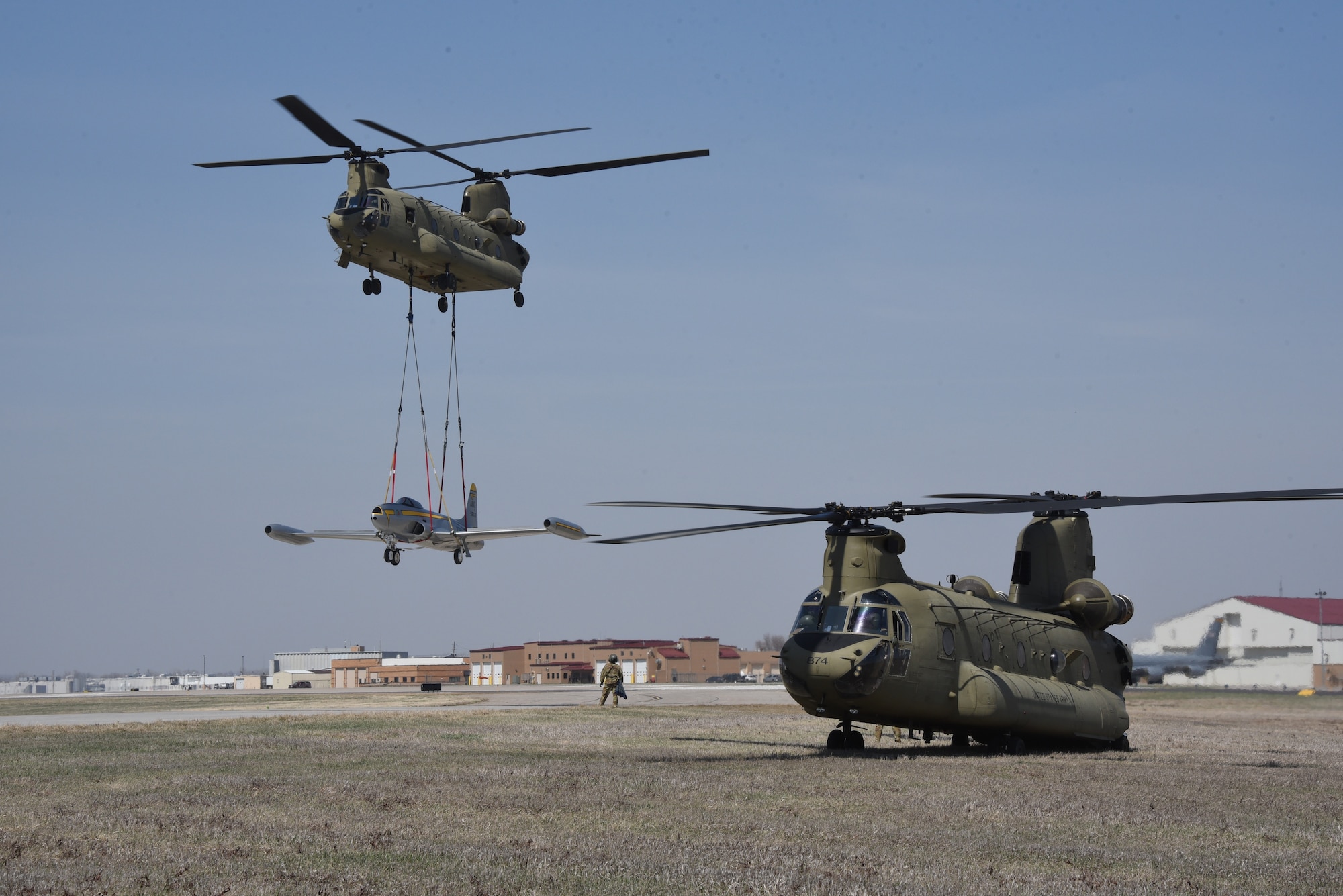 Iowa Army National Guard CH-47 Chinook helicopter picks up a F-80 fighter jet at the Air National Guard paint facility