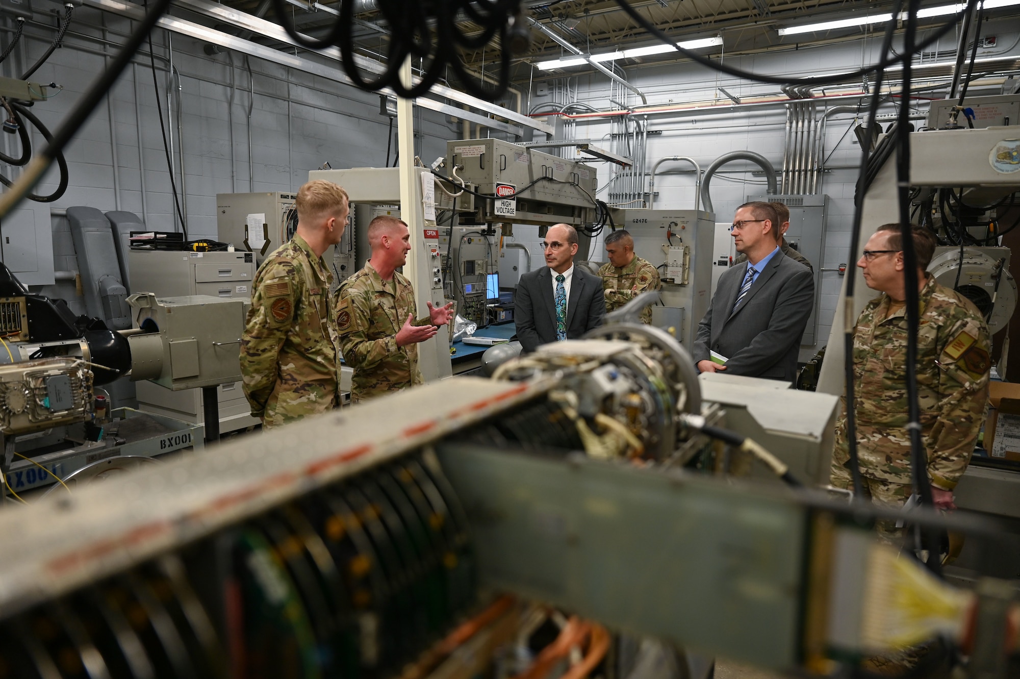 U.S. Air Force Staff Sgt. Jared Henderson, 36th Electronic Warfare Squadron technician, left, Master Sgt. Andrew Jennings, 36th EWS flight chief, left -center, brief John F. Vona, Air Combat Command deputy director of the plans, program and requirements directorate, center, and Dr. John D. Matyjas, ACC chief scientist, right, about the Reclamation of Electronic Attack Pods (REAP) at Eglin Air Force Base, Fla., April 11, 2023. The REAP program aims to leverage resources from the 350th Spectrum Warfare Wing and provide the receiving, diagnostic testing, recoupment, and shipment of EA pod equipment back into the supply chain for future use. (U.S. Air Force photo by Staff Sgt. Ericka A. Woolever)
