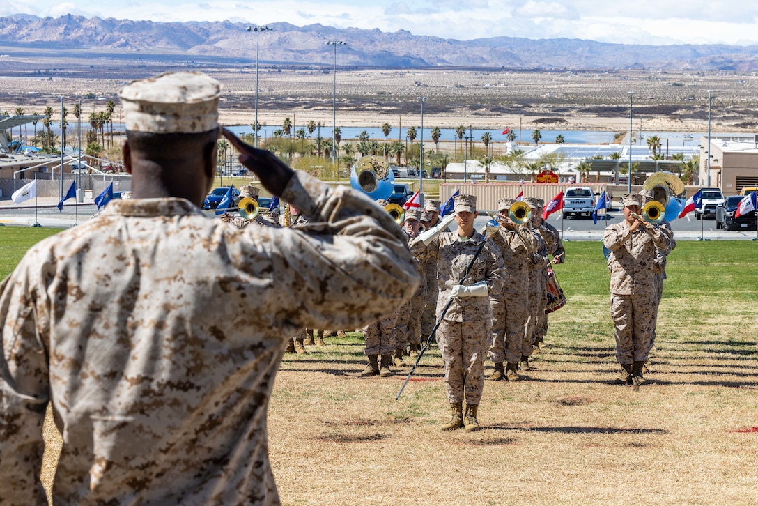 A US Marine salutes the 1st Marine Division band