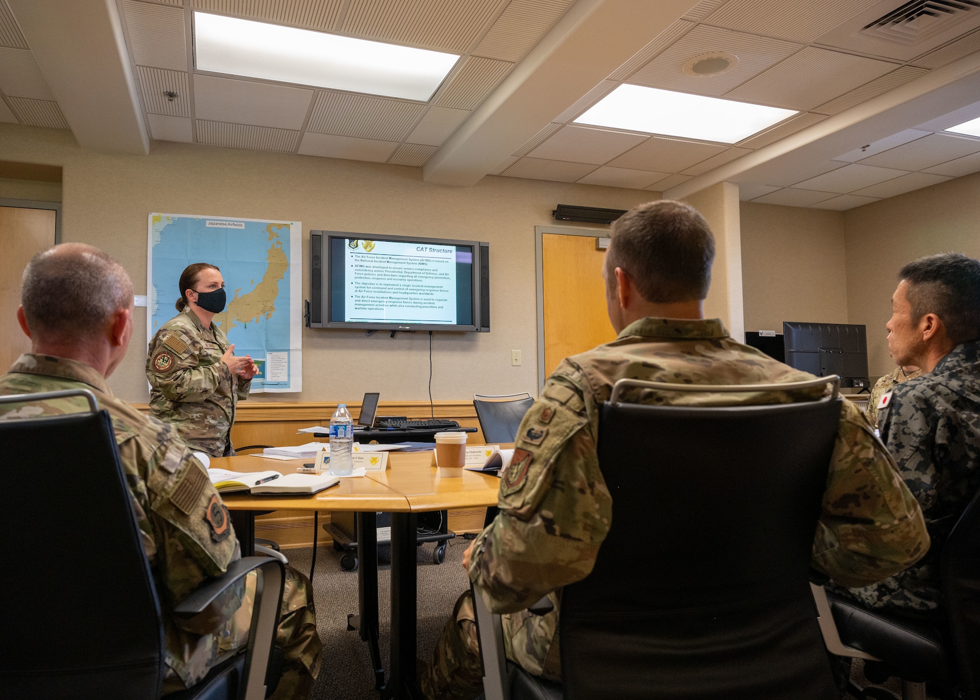 Photo of a U.S. Air Force chief master sergeant briefing officers from the Pacific Air Forces and Japan Air Self Defense Force.