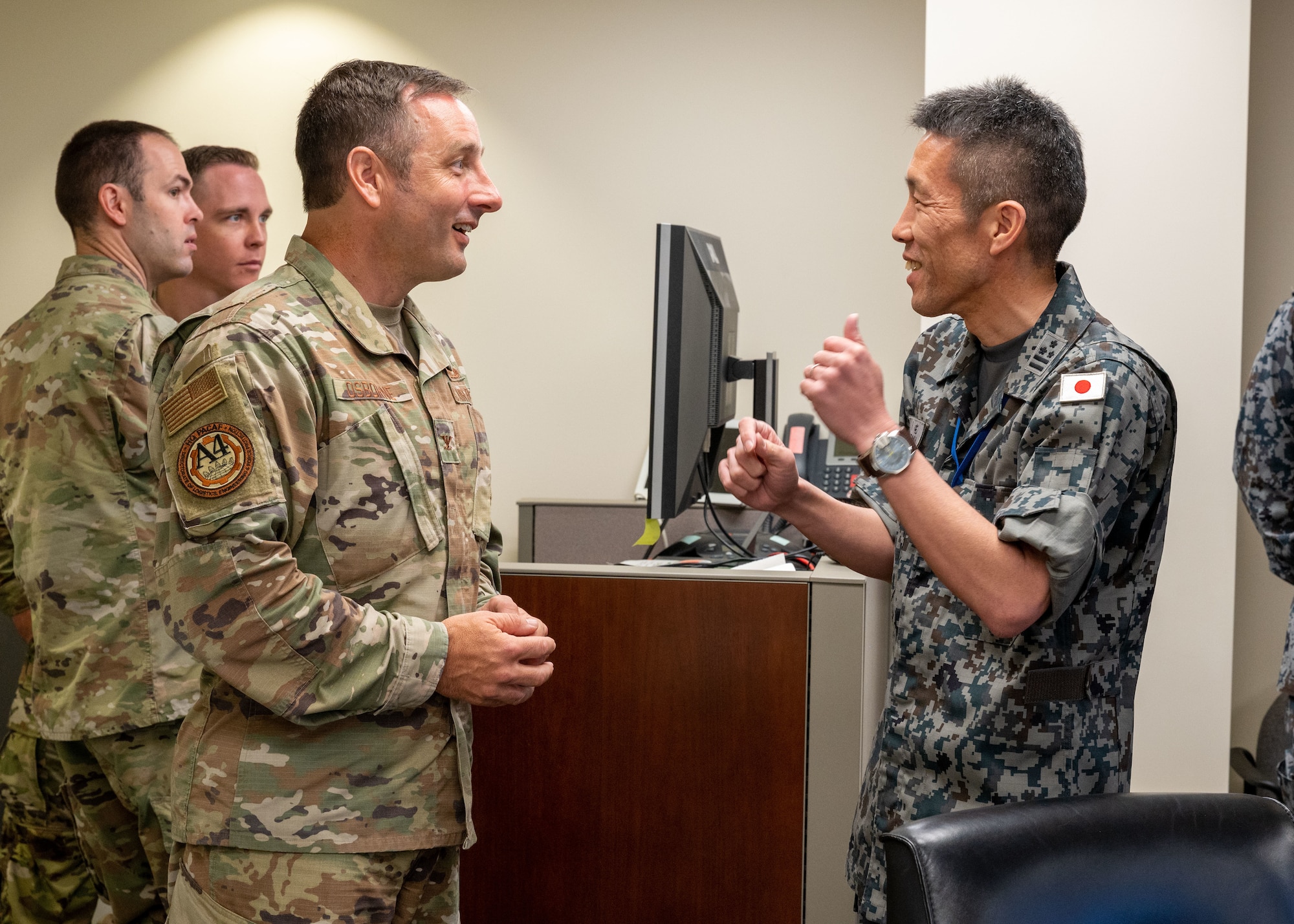 Photo of officers from U.S. Air Force and Japan Air Self Defense Force talking before a meeting.