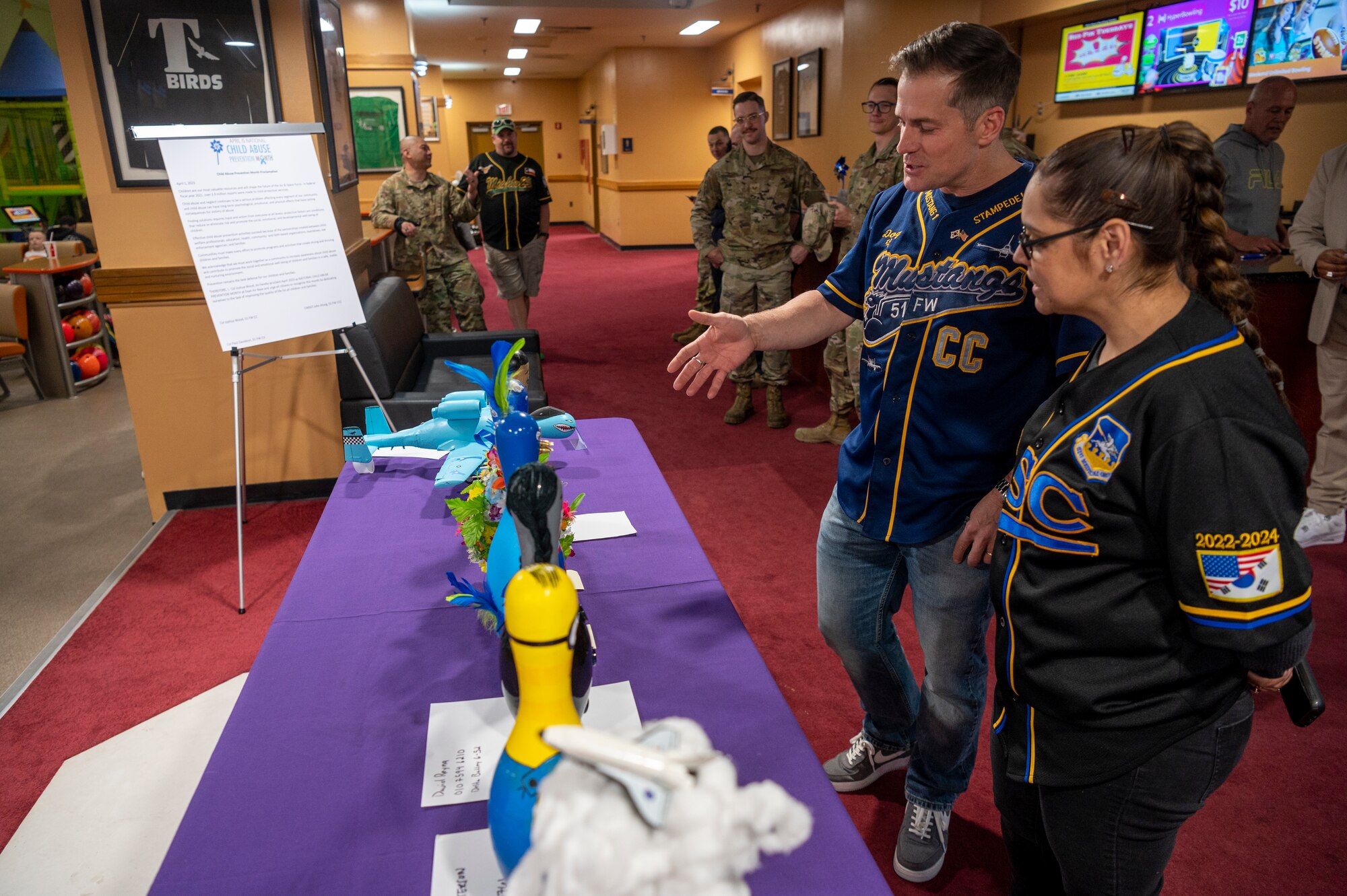 U.S. Air Force Col. Joshua Wood, 51st Fighter Wing commander, and Chief Master Sgt. Lisa Thrasher-Stallard, 51st Medical Group command chief, inspect submissions as judges to the bowling pin decoration contest at Osan Air Base, Republic of Korea, April 7, 2023. The contest was held in observance of National Child Abuse Prevention Month. (U.S. Air Force photo by Airman 1st Class Aaron Edwards)
