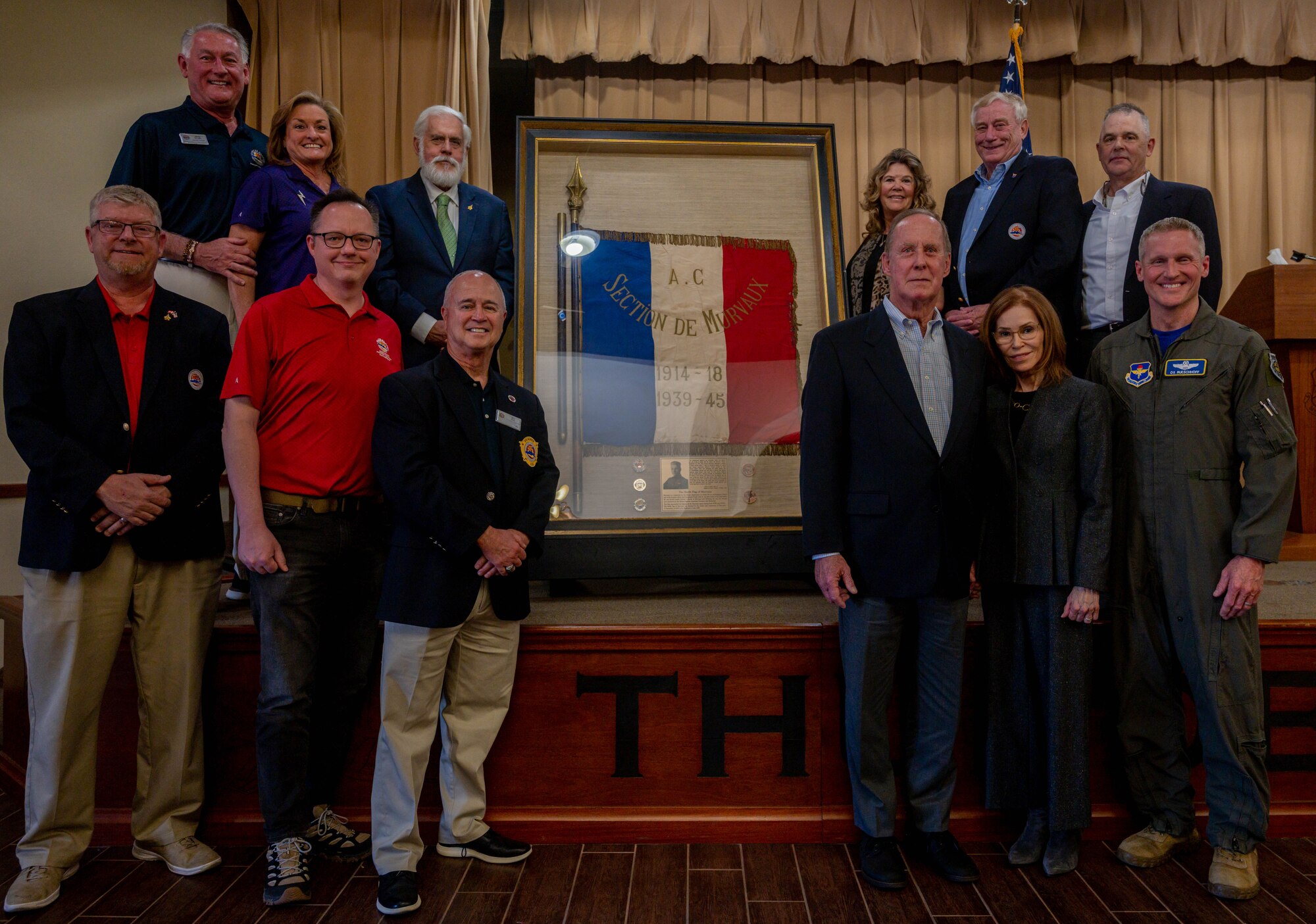 U.S. Air Force Brig. Gen. Jason Rueschhoff (right), 56th Fighter Wing commander, members of the Luke family and Fighter Country Foundation partners pose for a group photo in front of the Murvaux flag, May, 7, 2023, at Luke Air Force Base, Arizona.