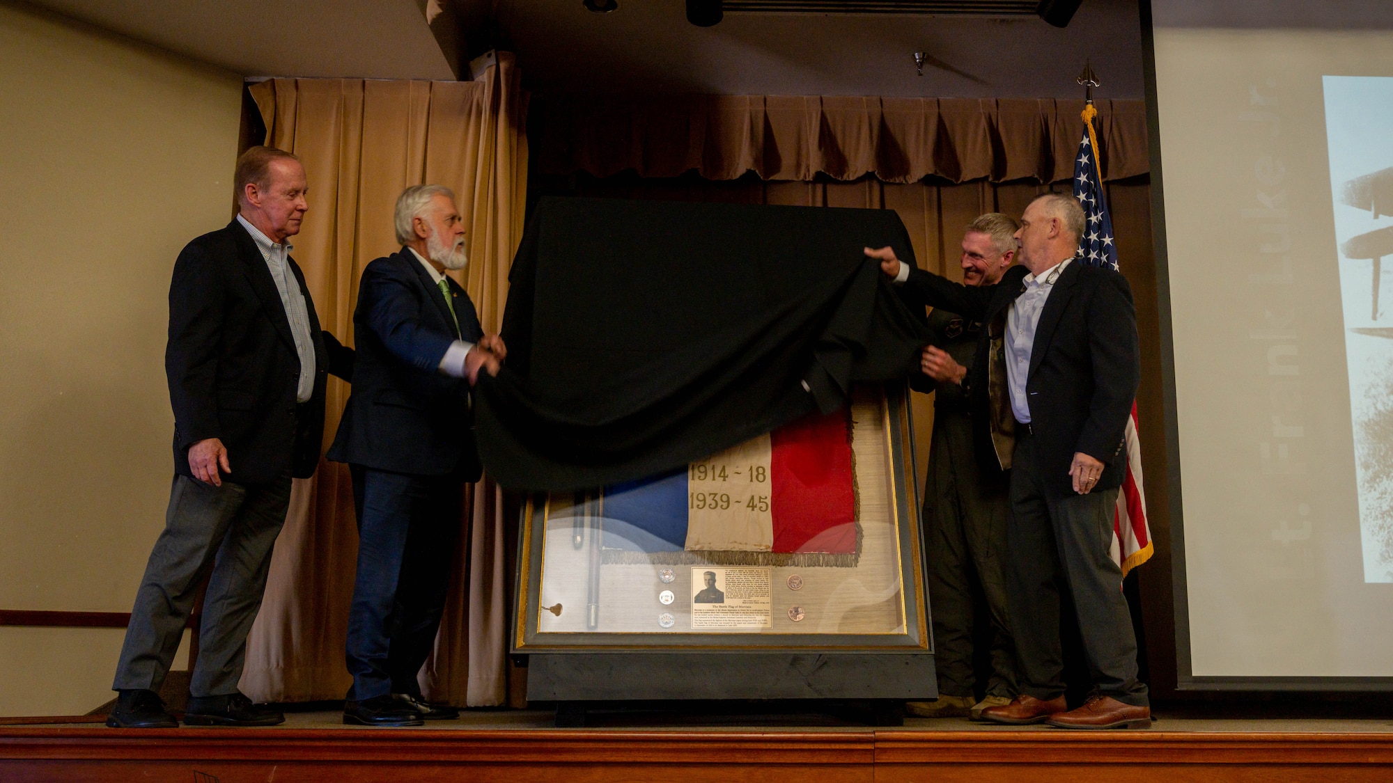 Participants in the Murvaux flag ceremony unveil the Murvaux flag May, 7, 2023, at Luke Air Force Base, Arizona.