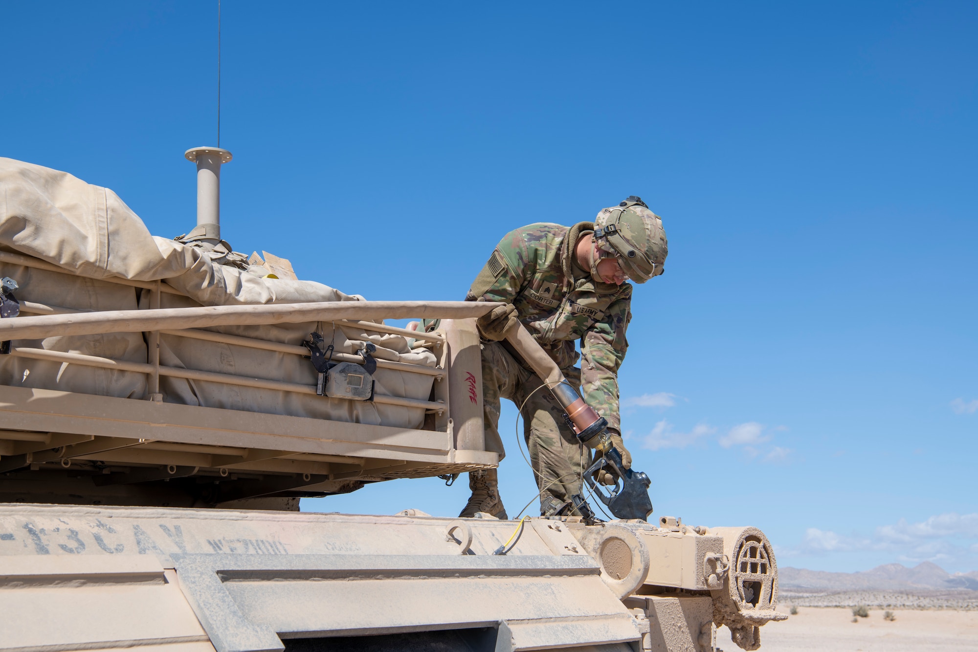 A U.S. Army Soldier from the 1st Armored Division refuels an M1A2 Abrams tank from a C-130J Super Hercules in the California desert during Operation Night King March 26, 2023.