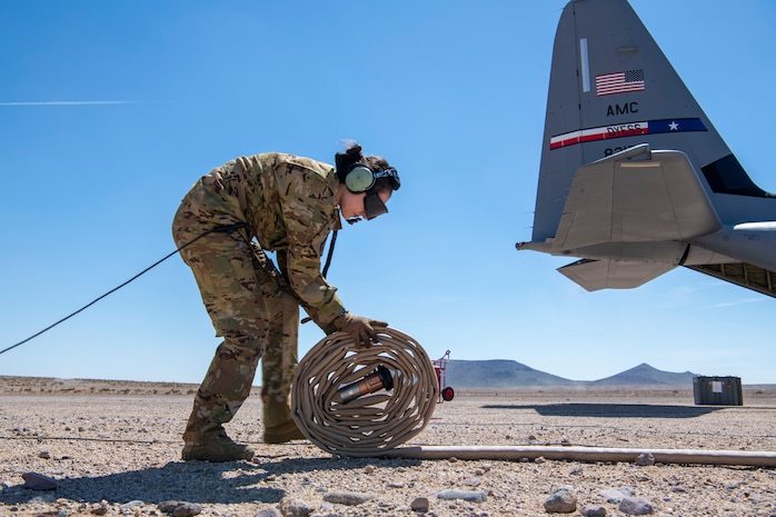 U.S. Air Force Tech. Sgt. Tristan Geray, 40th Airlift Squadron loadmaster, wraps up a fuel hose during Operation Night King in the California desert March 26, 2023.
