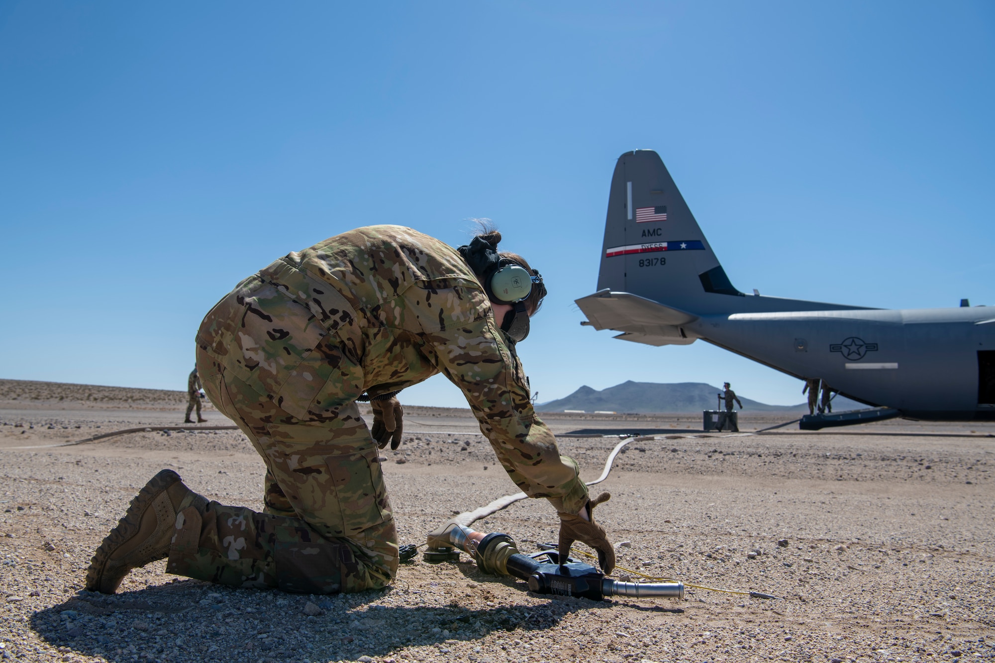 U.S. Air Force Tech. Sgt. Tristan Geray, 40th Airlift Squadron loadmaster, grabs the fuel hose of the C-130J Super Hercules during Operation Night King in the California desert March 26, 2023.