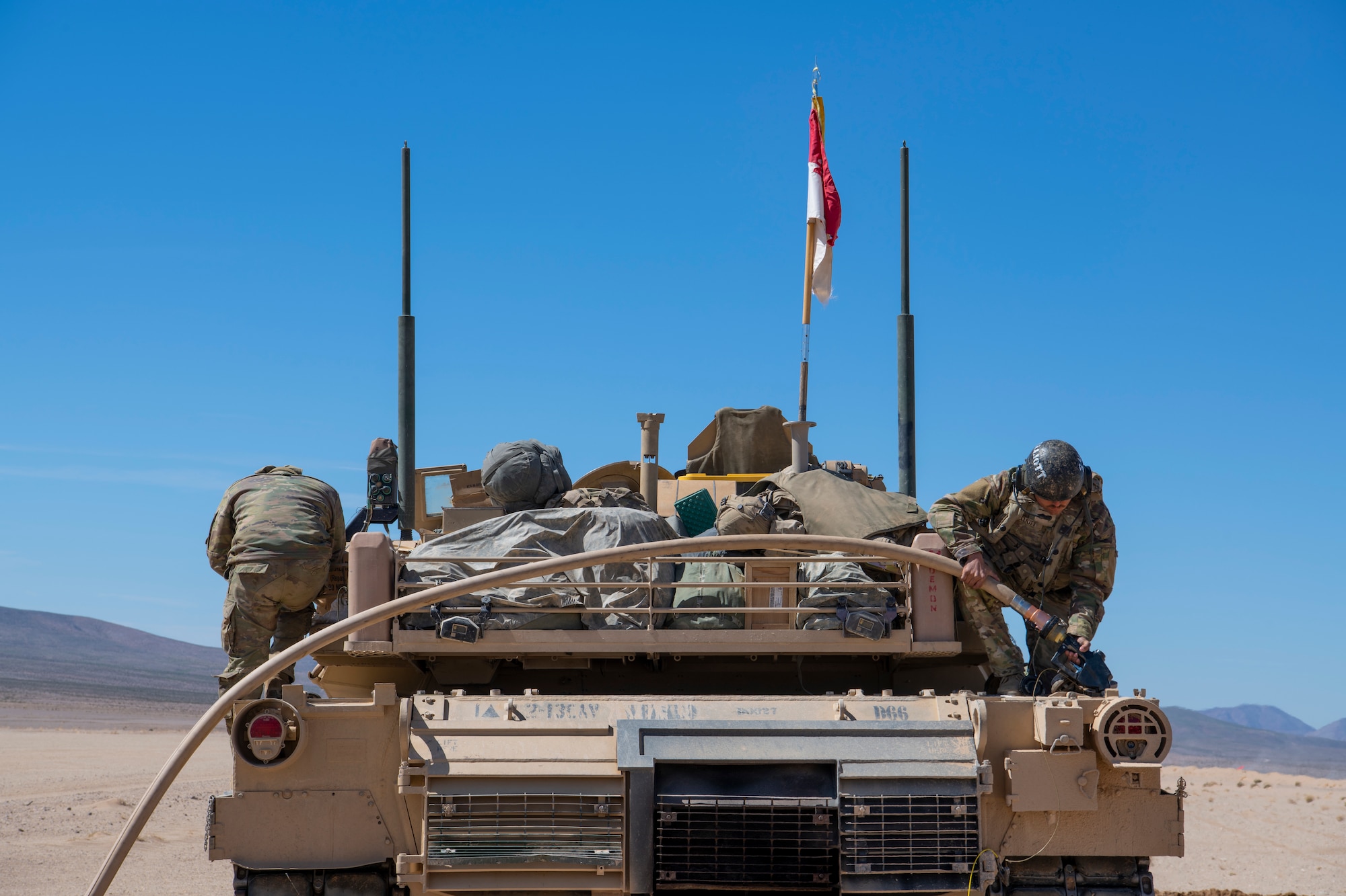 U.S. Army Soldiers from the 1st Armored Division refuel an M1A2 Abrams tank from a C-130J Super Hercules during Operation Night King in the California desert March 26, 2023.