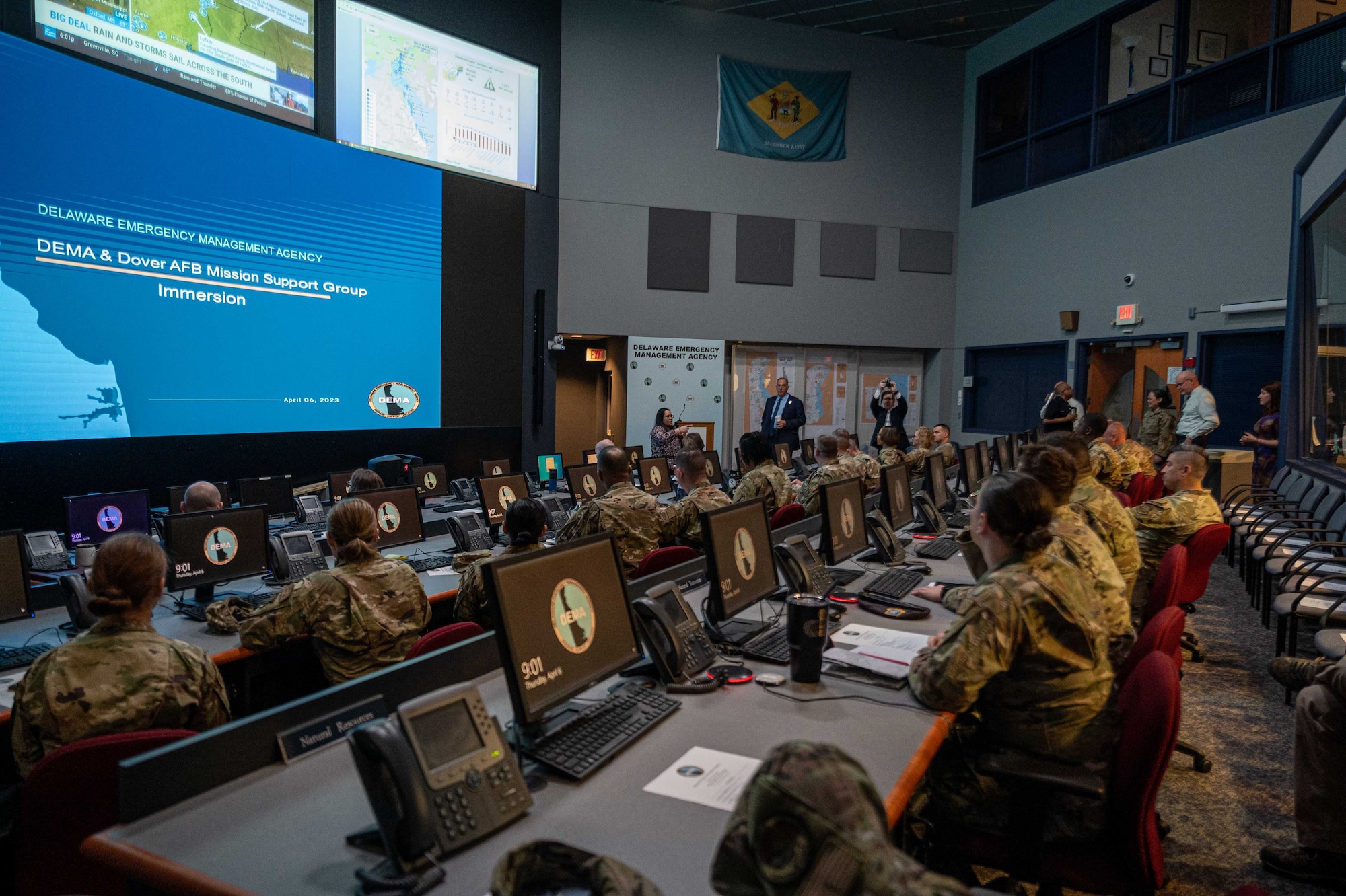 Representatives from the 436th Mission Support Group and the 512th MSG are briefed on the Delaware Emergency Management Agency emergency operations center during an immersion event in Smyrna, Delaware, April 6, 2023. During the event, DEMA was able to share best practices with Team Dover Airmen regarding preparedness for natural disasters, terrorism response, emergency operations center training, behavior threat analysis for school safety and community engagement. (U.S. Air Force photo by Senior Airman Faith Barron)