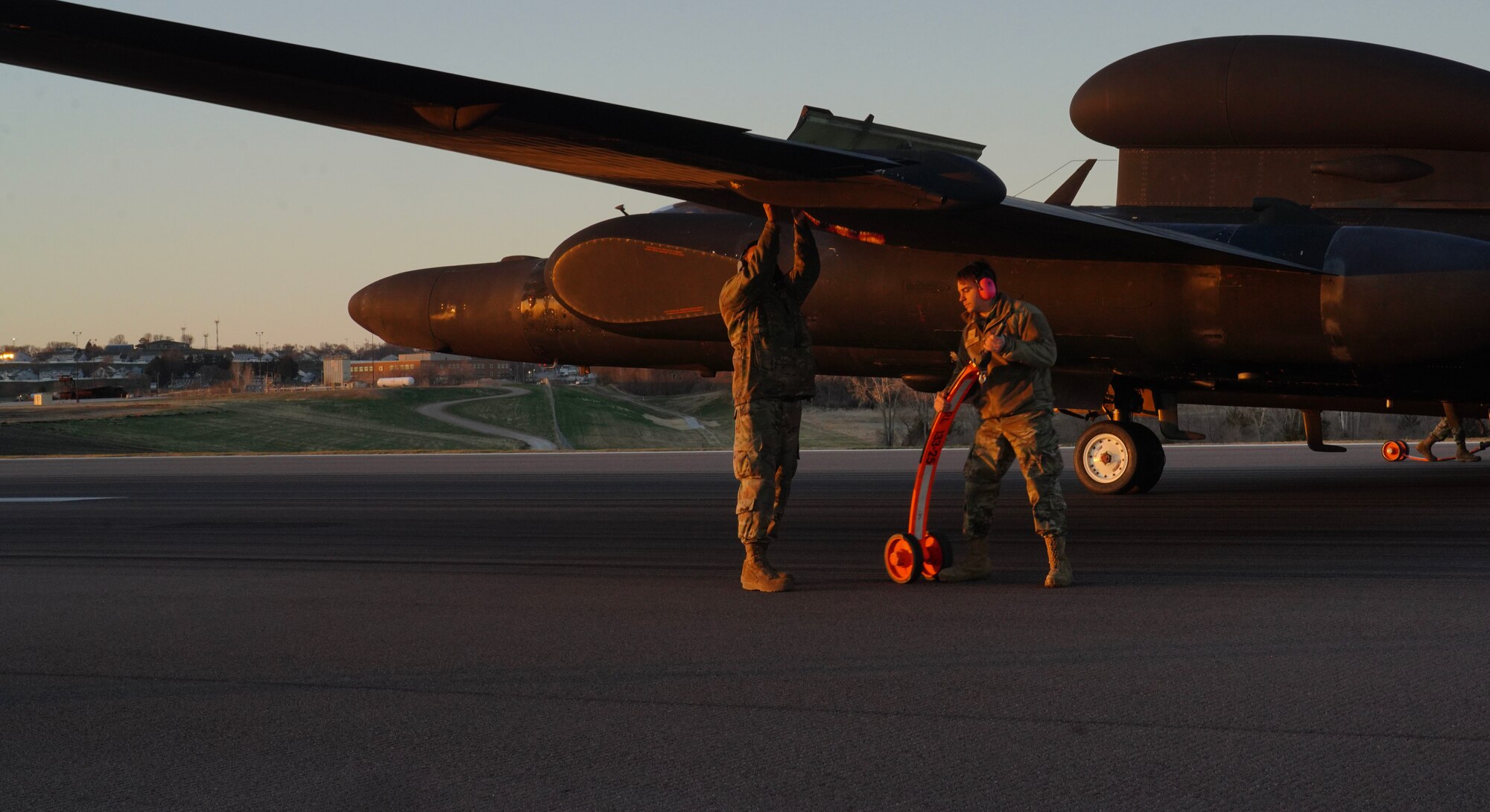 A U.S. Air Force 9th Aircraft Maintenance Squadron Airman and a 9th MXS Airman weigh on the wing of a U-2 Dragon Lady to place a pogo during Dragon Flag EAST, April 5, 2023, at Offutt Air Force Base, Nebraska.