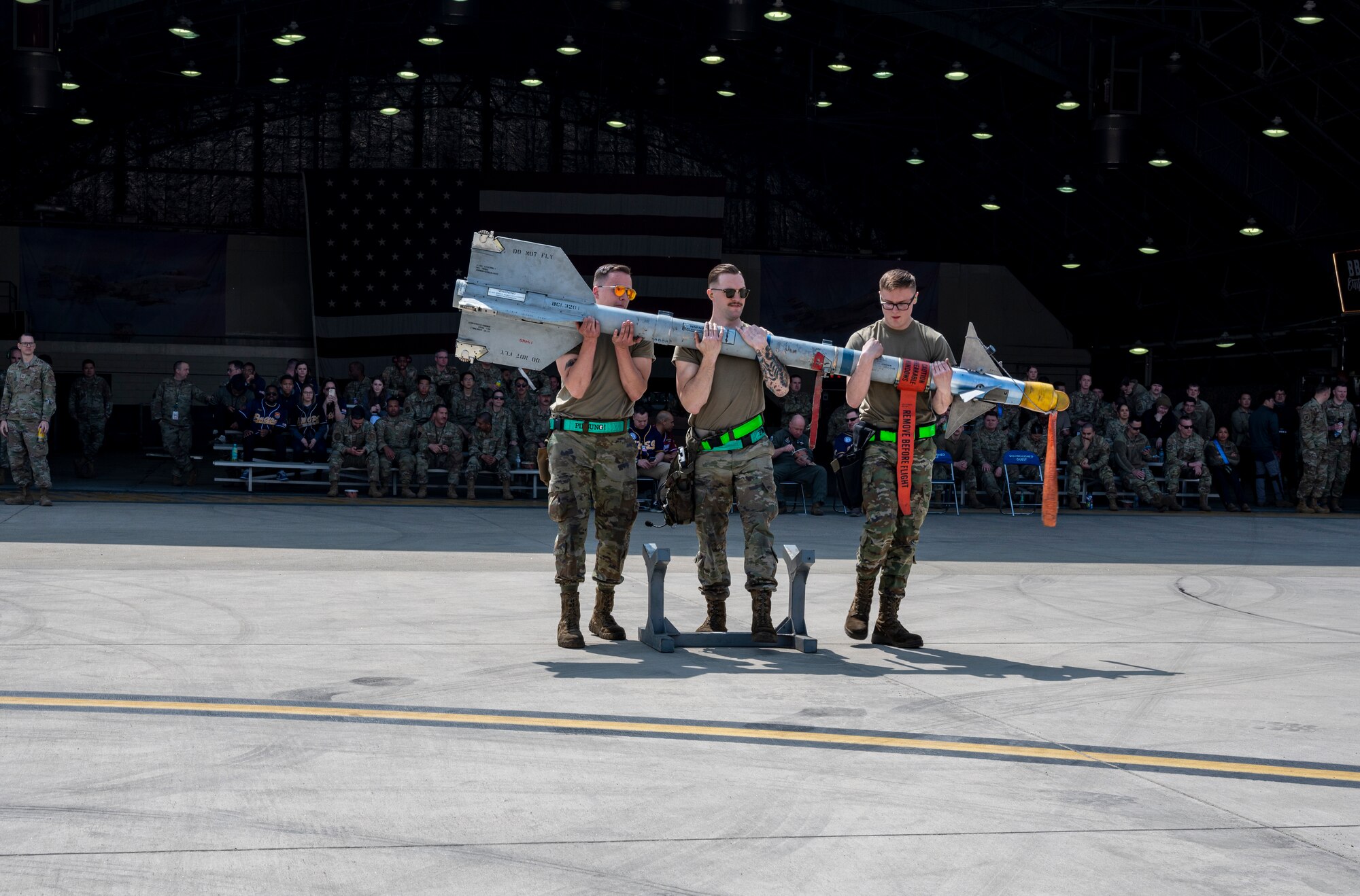From the left, U.S. Air Force Airman 1st Class Blaze Winter, Staff Sgt. Andre Kitz and Airman 1st Class Benjamin Lenaker, 25th Fighter Generation Squadron weapons load crew members, carry an AIM-9L/M Sidewinder during a weapons load crew of the quarter competition at Osan Air Base, Republic of Korea, March 31, 2023. T