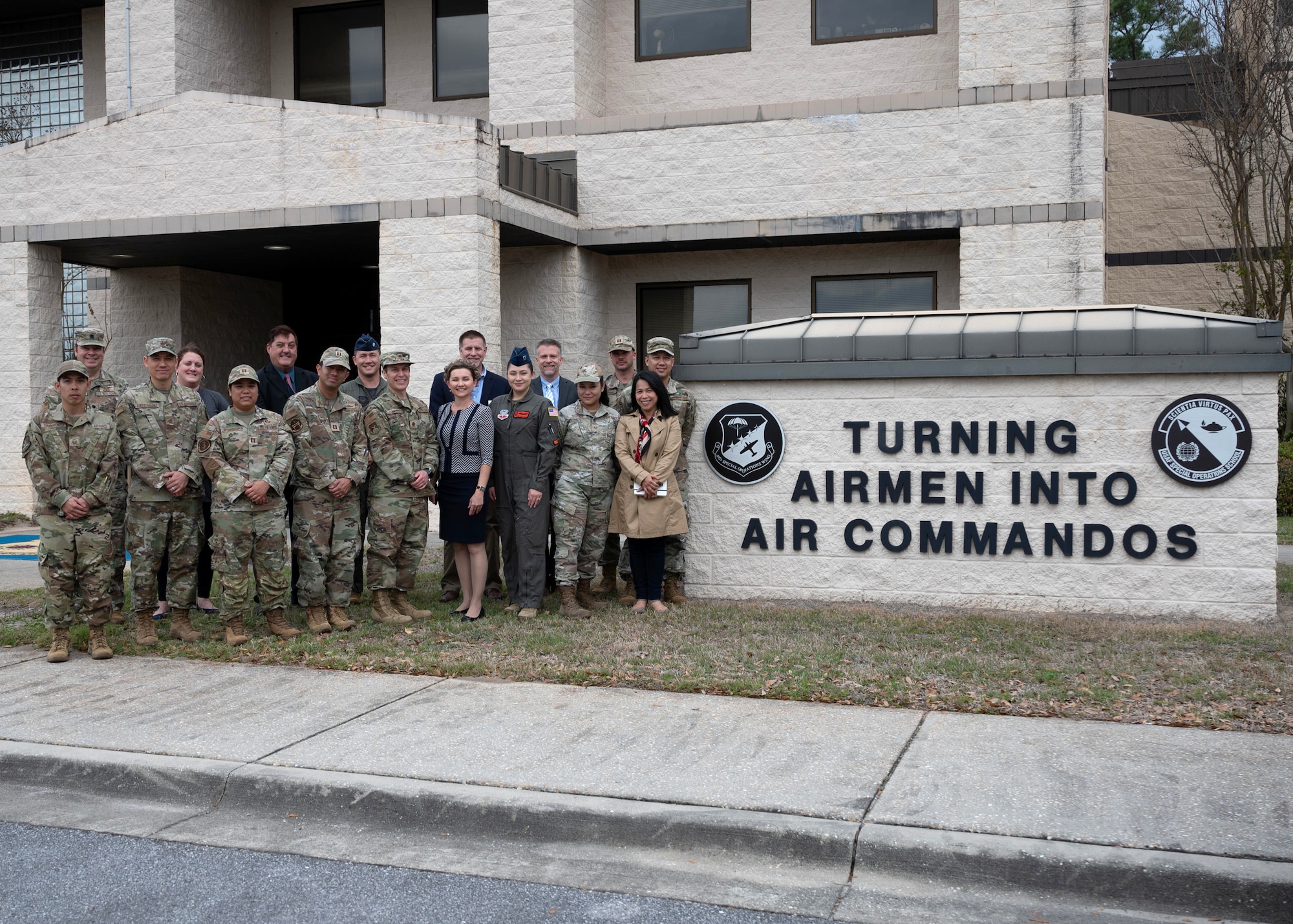 Airmen standing in front of a sign