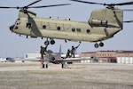 An Iowa Army National Guard CH-47 Chinook helicopter picks up a historic F-80 fighter jet from the Air National Guard paint facility in Sioux City, Iowa, April 11, 2023. The helicopter from the Iowa National Guard B/171 Aviation Regiment based in Davenport brought the jet back to Camp Dodge to be placed on static display.