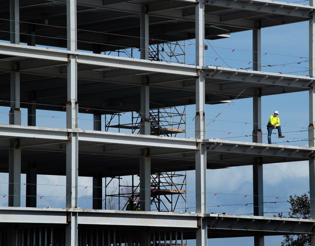 A construction worker watches the top off ceremony from the third floor of the 325th Force Support Squadrons’ future lodging facility at Tyndall Air Force Base, Florida