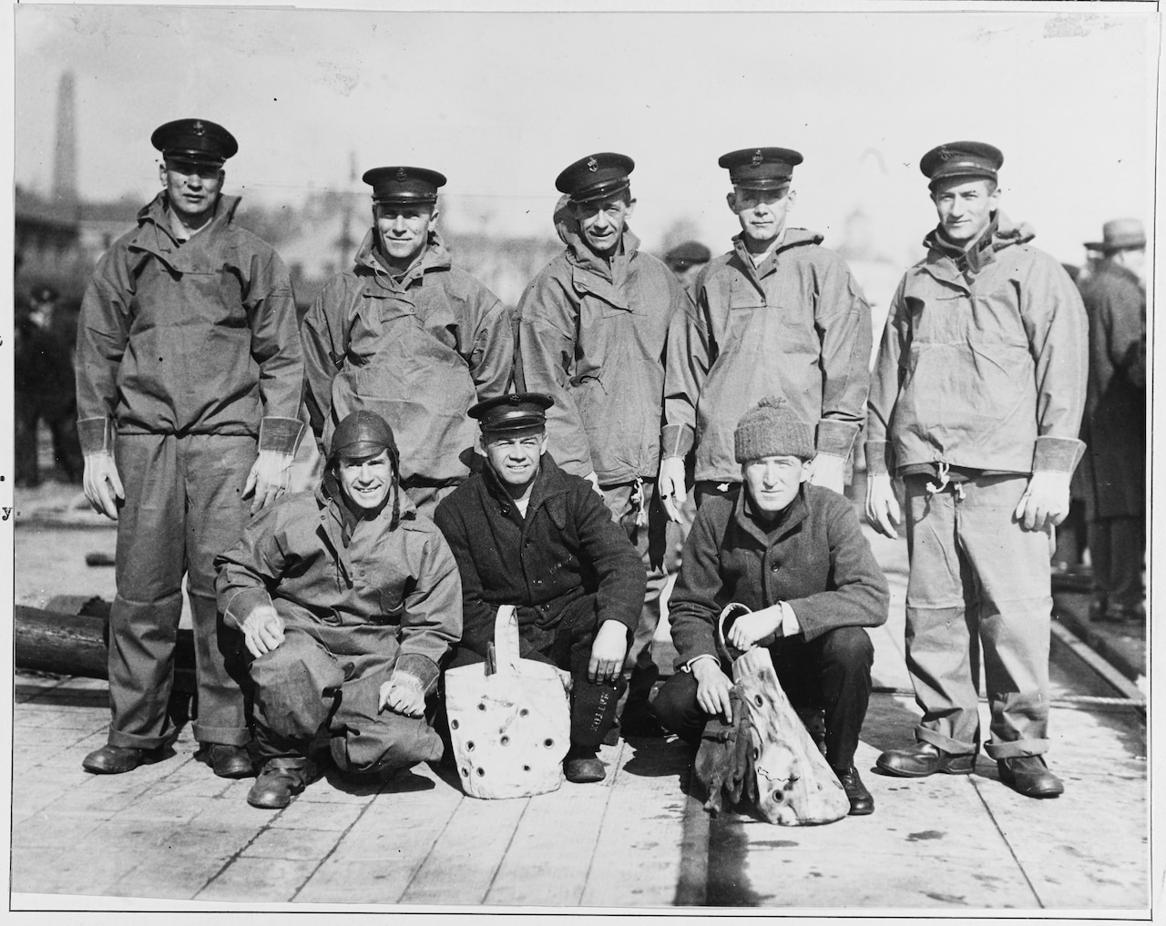 Five men stand as three squat in front of them to pose for a photo.