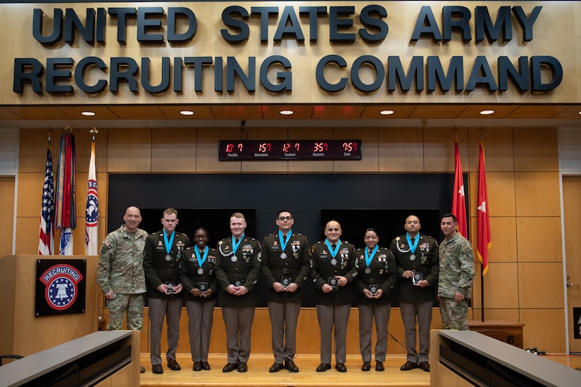 People stand in Army uniform on a stage.