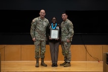 People stand in Army uniform on a stage.