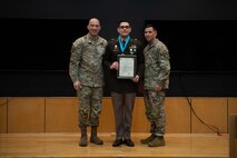 People stand in Army uniform on a stage.