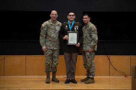 People stand in Army uniform on a stage.