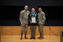 People stand in Army uniform on a stage.