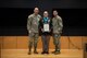 People stand in Army uniform on a stage.