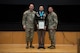 People stand in Army uniform on a stage.