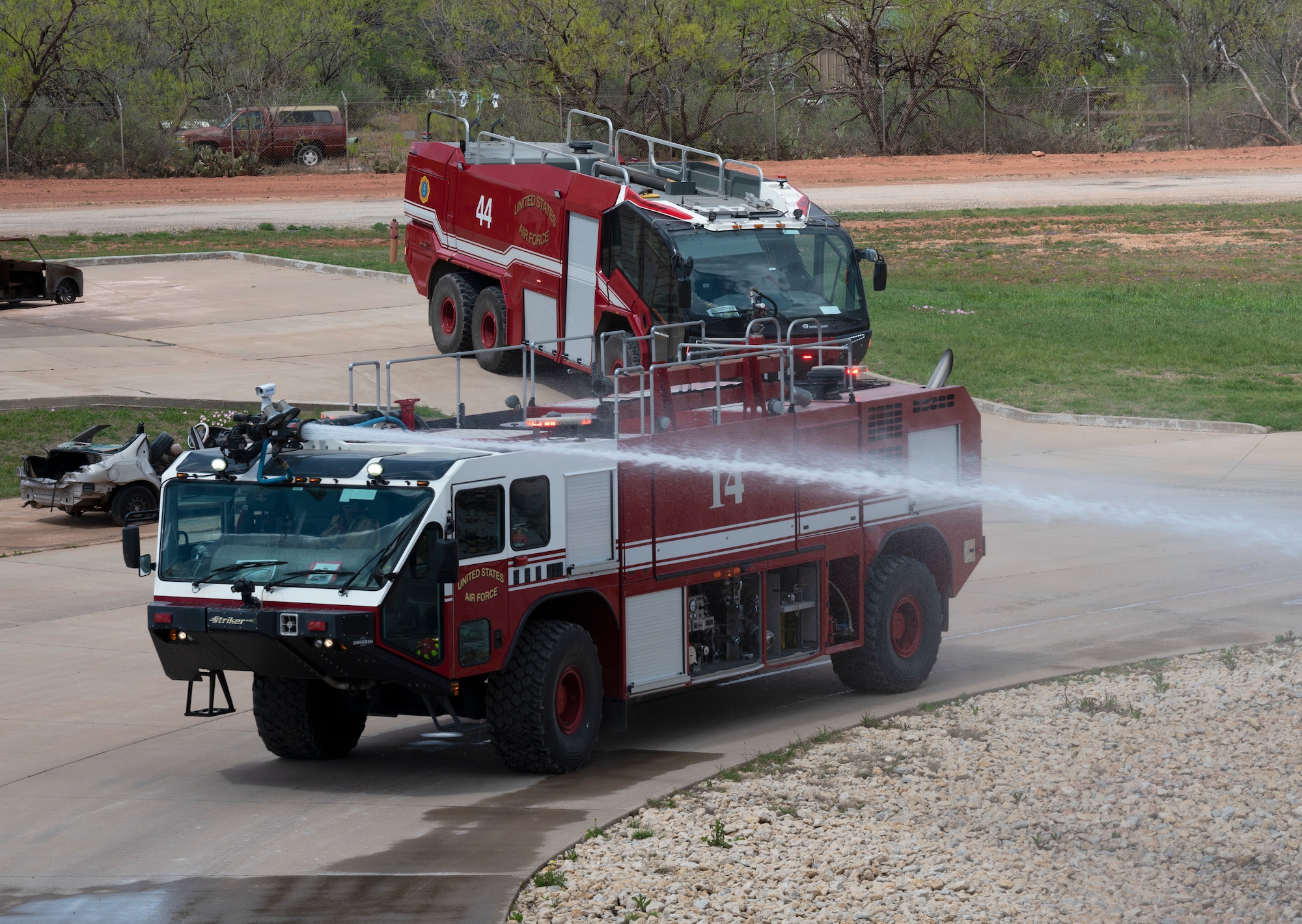 Firefighters from the 7th Civil Engineering Squadron extinguish a fire during a live fire training drill on Dyess Air Force Base, Texas, April 10, 2023. Firefighters from the 7th CES trained with Dallas Fort Worth and Abilene firefighters to educate them on effectively using Ultra High-Pressure systems to extinguish fires in minimal time. The training was held to not only educate civilian firefighters on Ultra High-Pressure systems but also to strengthen the partnership with local and state fire departments. (U.S. Air Force photo by Airman Emma Anderson)