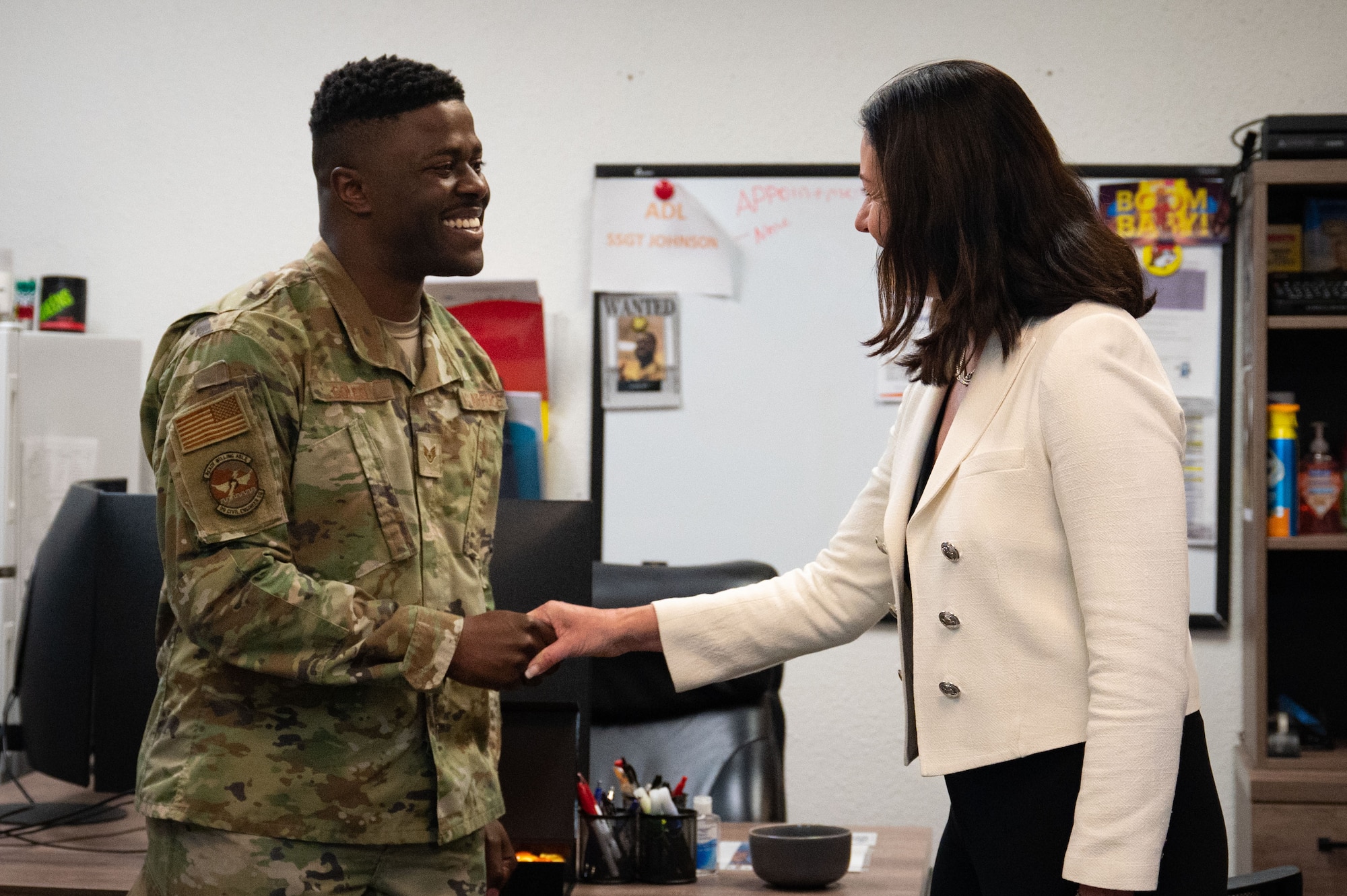 Staff. Sgt. Aaron Coles, 99th Civil Engineer Squadron Airmen dorm leader, receives a coin the Hon. Kristyn Jones, assistant secretary of the Air Force for Financial Management and Comptroller, performing the duties of under secretary of the Air Force, at Nellis Air Force Base, April 7, 2023.