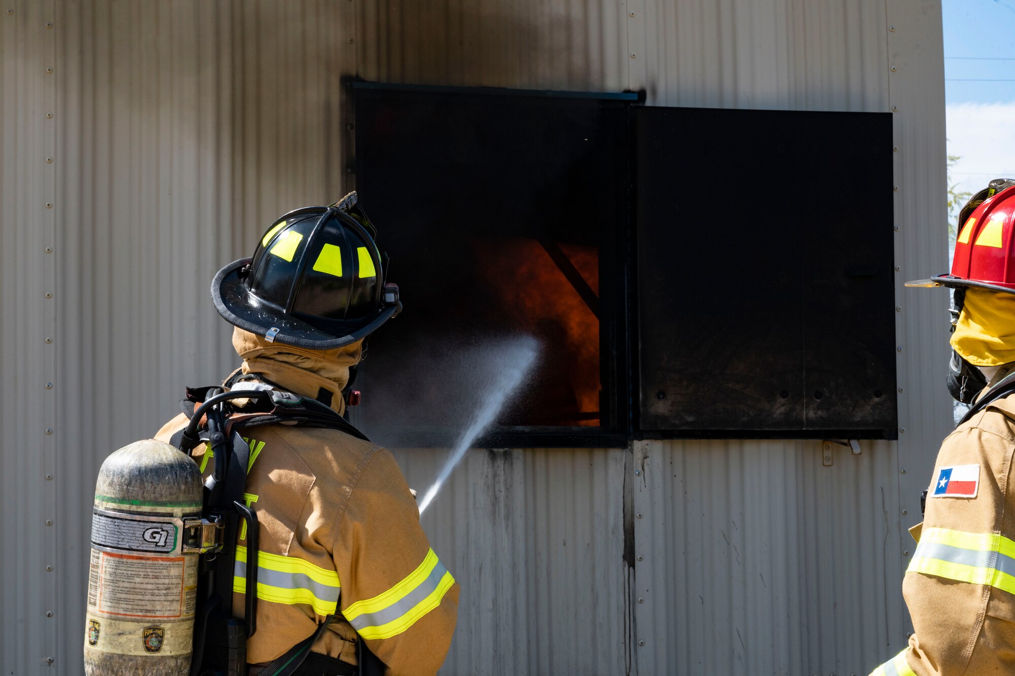 Dallas Fort Worth firefighters extinguish a live fire at a fire training site in Abilene, Texas, April 10, 2023. Firefighters from the 7th Civil Engineering Squadron trained with Dallas Fort Worth and Abilene firefighters to educate them on effectively using Ultra High-Pressure systems to extinguish fires in minimal time. The training was held to not only educate civilian firefighters on Ultra High-Pressure systems but also to strengthen the partnership with local and state fire departments. (U.S. Air Force photo by Airman Emma Anderson)