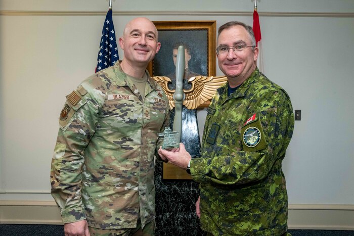 Air University Command Chief Master Sgt. Stefan Blazier exchanges gifts with Royal Canadian Air Force Command Chief Warrant Officer John Hall at Maxwell Air Force Base, Mar. 30, 2023. Hall visited Maxwell to support three RCAF members attending Airman Leadership School, provide the keynote address at the ALS graduation, and to conduct a bi-lateral meeting with Chief Master Sergeant of the Air Force JoAnne S. Bass. (US Air Force photo by Melanie Rodgers Cox)