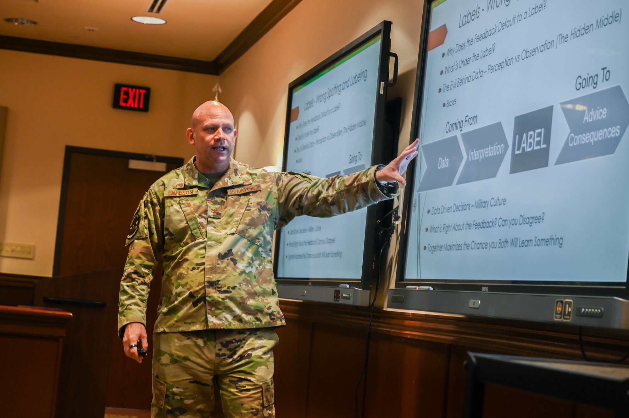 U.S. Air Force Col. Davidson, 47th Flying Training Wing commander, explains a PowerPoint presentation to his team during a professional development discussion at Laughlin Air Force Base, Texas, on March 22, 2023. The discussion focused on the importance of feedback and developing leaders within the Air Force. (U.S. Air Force photo by Airman 1st Class Keira Rossman)