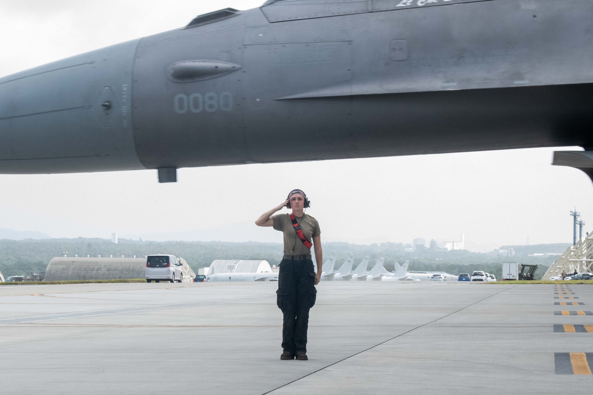 An Airman salutes an aircraft as it departs.