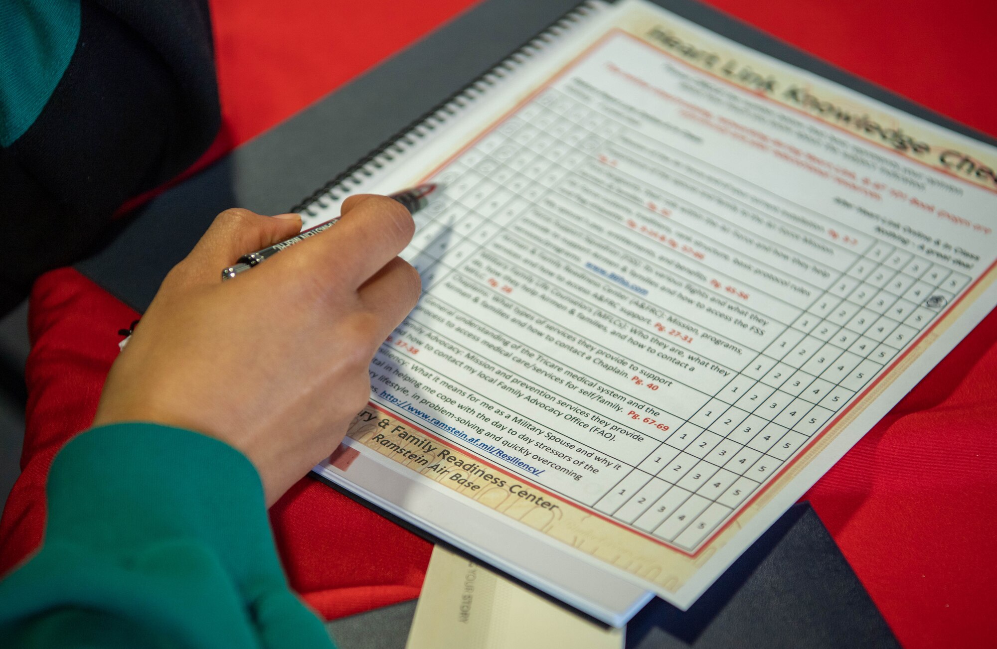 A military spouse attending a Heart Link course fills out a knowledge check worksheet prior to learning about base resources at Ramstein Air Base, Germany, April 4, 2023.