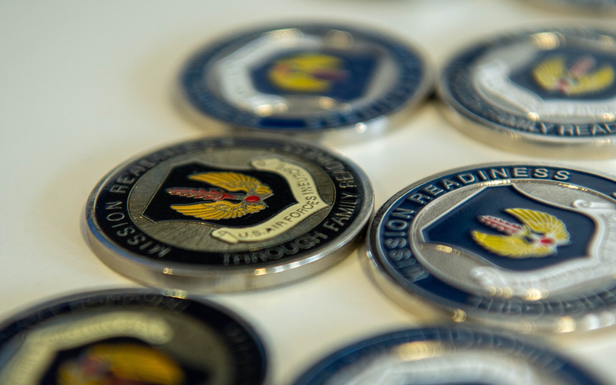 Coins are displayed on a table before the coining ceremony during a Heart Link course at Ramstein Air Base, Germany, April 4, 2023.