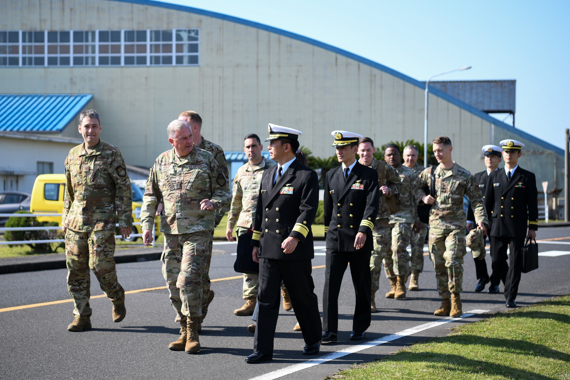 Leaders of United States Forces Japan, the 374th Airlift Wing, and the 319th Expeditionary Reconnaissance Squadron walk to the Kanoya Air Base headquarters building during a visit to Kanoya Air Base, Japan, April 10, 2023. USFJ and 374th AW command teams also met with Shigeru Nakanishi, Kanoya mayor, and recognized Airmen from the 319th ERS for their commitment to contributing positively to the Kanoya community. (U.S. Air Force photo by Staff Sgt. Spencer Tobler)